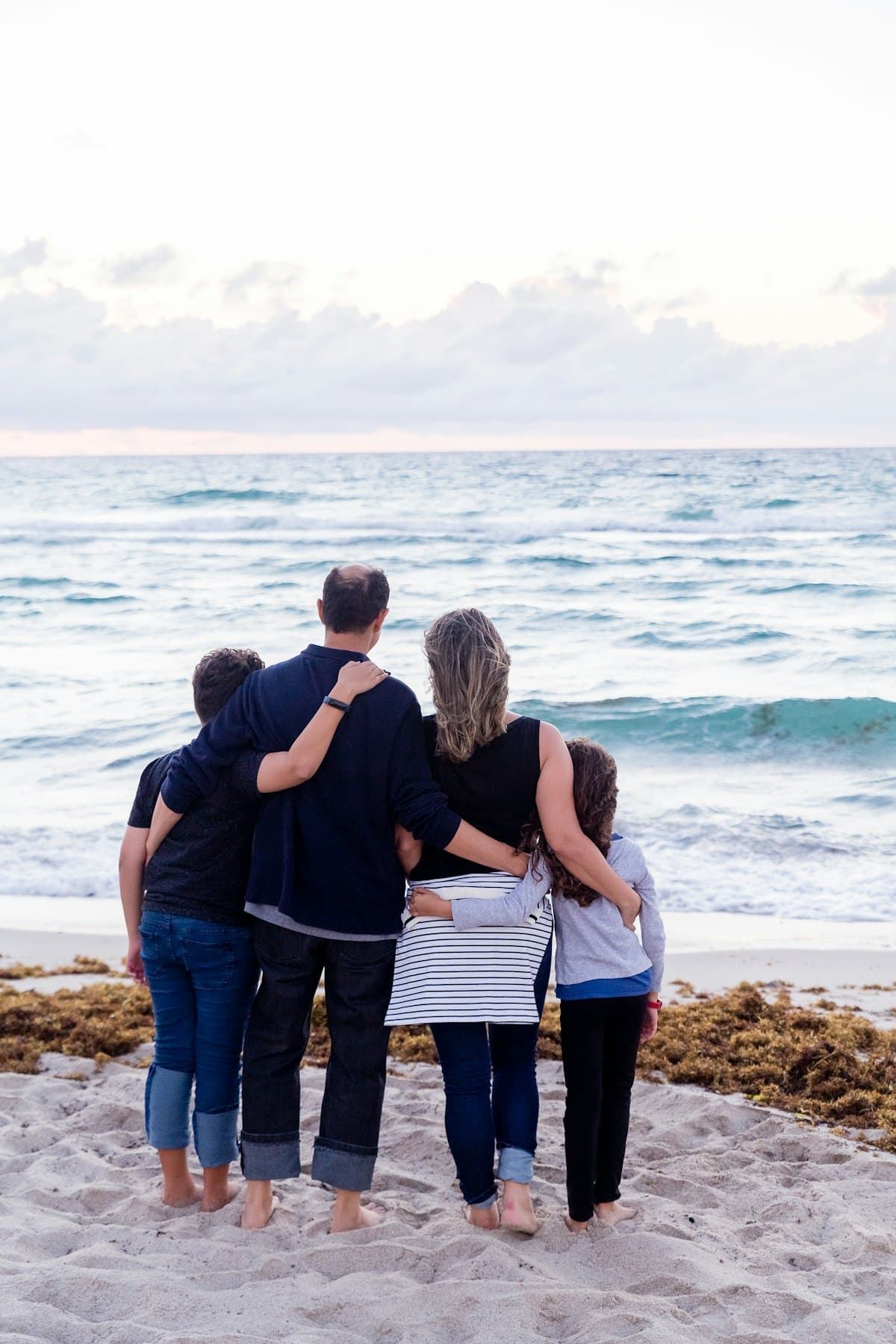 A family standing together looking out at the sea