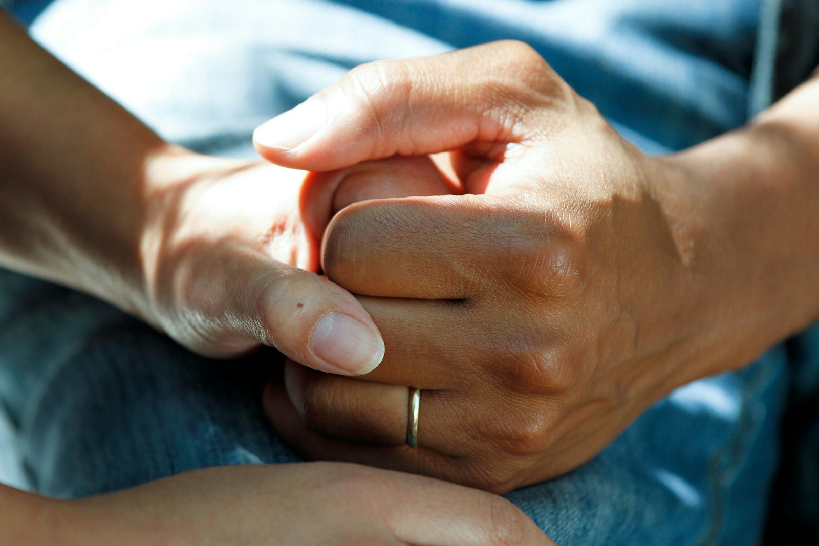 Caring hands held in support during a medical consultation
